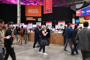 A group of conference attendees looking at startup exhibitions.